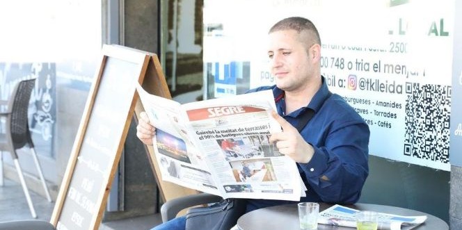 Un lector de 'Segre' en una terrassa en una imatge d'arxiu / SEGRE